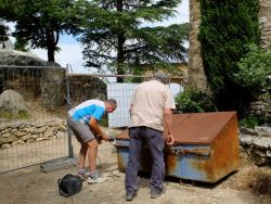 Puis, aidé de Marc D., il découpe un long fer à béton avant de le fixer à la clôture