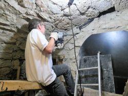 Mai 2019, Laurent Fuxet perce les murs épais de la cave pour permettre le passage des gaines