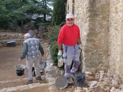 Alain T. dégage le tas de grosses pierres devant le logis 