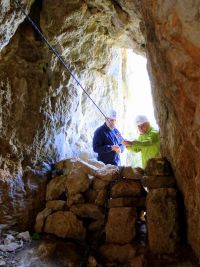 Un muret sauvage bouche partiellement la sortie en falaise, par laquelle descendaient les moines.