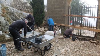 Noëlle et Jacques Païta gâchent le mortier, Laurent Fuxet cherche des pierres appropriées