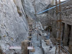 A gauche, l'étroit espace entre le mur et la falaise sera caladé. Un regard y est posé.