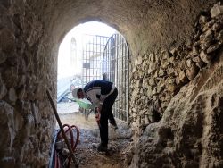 Yann attaque le seuil de la grille d'entrée du cloître au marteau piqueur