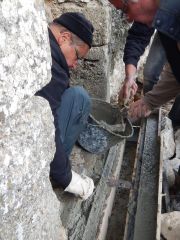 Le béton est coulé dans le coffrage, de part et d'autre du caniveau