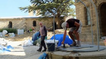 Marc L. pompe l'eau. Derrière Alain, Sauveur et Marc s'affairent autour du groupe