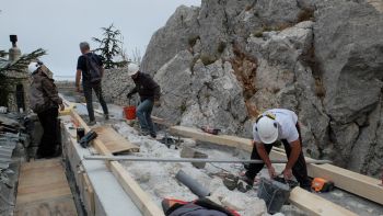 Visite de chantier. Larry et Hasni maçonnent des appuis pour fixer la panne intermédiaire