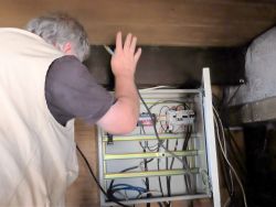 Dans la mezzanine, Alain met de l'ordre dans l'ancien tableau électrique qui ne reçoit à présent que l'électricité des panneaux photovoltaïques