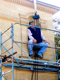 Jo contrôle le palan en s'y suspendant et s'assure que la niche sera assez large pour recevoir la statue!